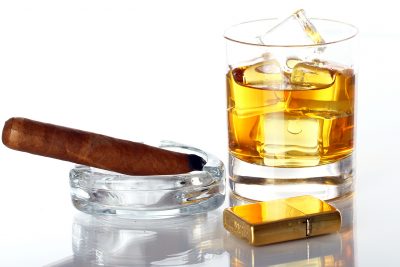 Glass of Whiskey and Cigar against white background